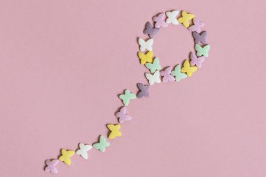 Hamur işi çok renkli kelebekler pembe arka planda bir balon şeklinde serilirler. Şekerleme ürünlerinin dekorasyonu