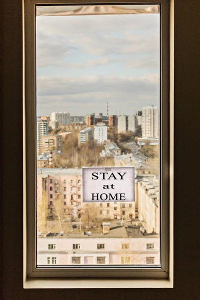 窗户上有城市的风景和英文的 呆在家里 在家里单独呆的重要性 以防止大肠埃希菌感染 — 图库照片