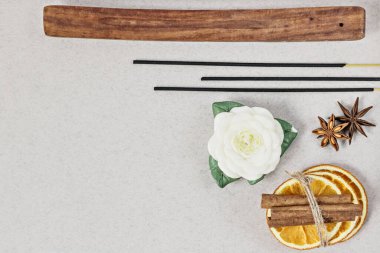 Tütsü ayakta duruyor, ahşap bir kâse ve anason yıldızında turuncu daireler çiziyor, tarçın gri bir zemine yapışıyor. Çiçek ve kabuk şeklinde mum. Ev spa konsepti