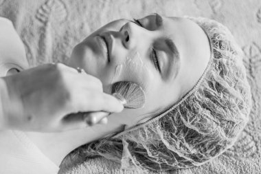 Yüzüne bir fırça ile tıbbi maske tak. Cilt bakımı. Spa ve güzellik konsepti.