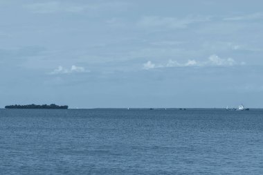 Finlandiya Körfezi kıyıları klasik maviyle. Ufuktaki ada ve yelkenliler klasik maviyle