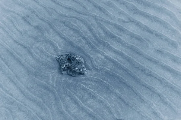 Background of the seabed sand with stone in classic blue