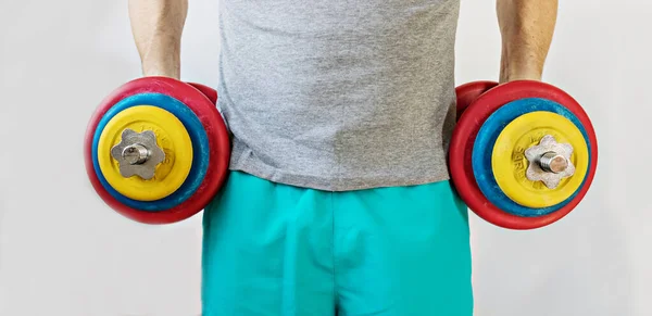 2本の手に重いダンベルを持つ男性選手 コロナウイルス流行中のホームワークアウト 健康的なライフスタイルの概念 バナー — ストック写真