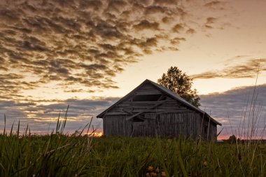 Yaz ortası günbatımı ve eski bir ahır ev