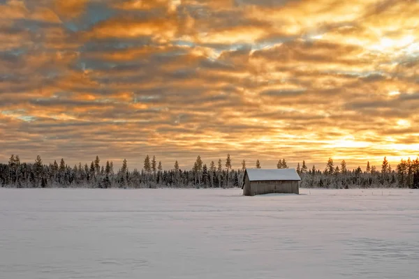 Mała szopa dom pokryty śniegiem pod dramatyzm nieba — Zdjęcie stockowe