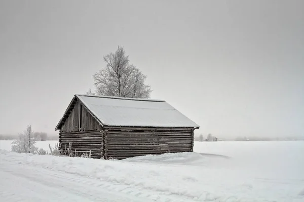 Snötäckta ladugård vid vägen — Stockfoto