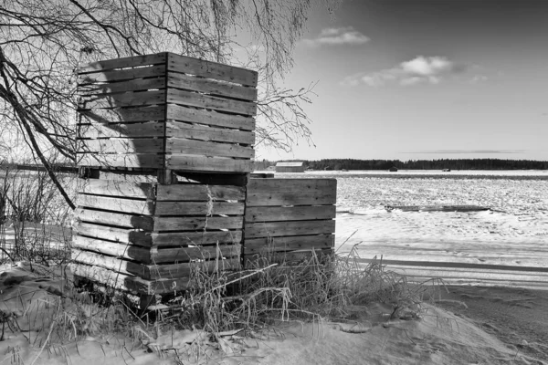 農家はフィンランドの田舎の雪原に3つの木枠を積んでいる その箱は白いもののためにそこに立っている 霜がかれらを覆い — ストック写真