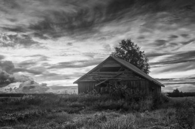 Finlandiya 'nın kırsalında eski bir ahır evinde yaz güneşi dramatik bir şekilde batar..