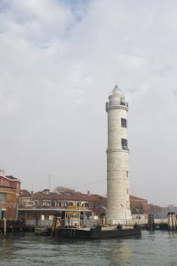 Kışın bulutlu bir günde gemiden Faro di Murano 'ya bakın.