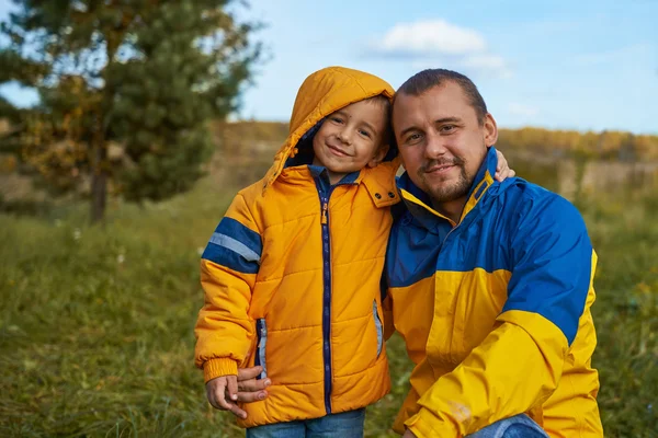 Portrait of a happy man and a child on autumn nature — Stock Photo, Image