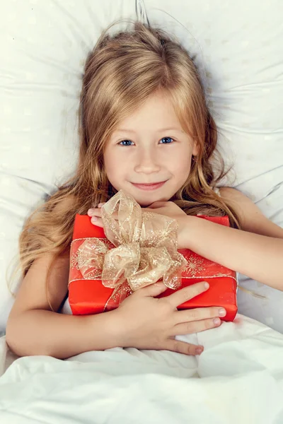 Retrato de niña feliz con un regalo en sus manos — Foto de Stock