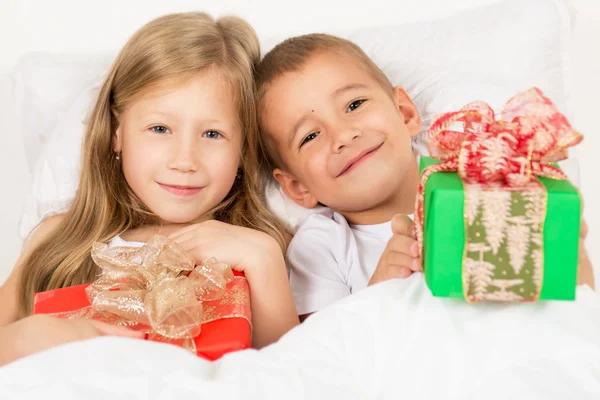 Retrato de um menino e menina com presentes nas mãos — Fotografia de Stock