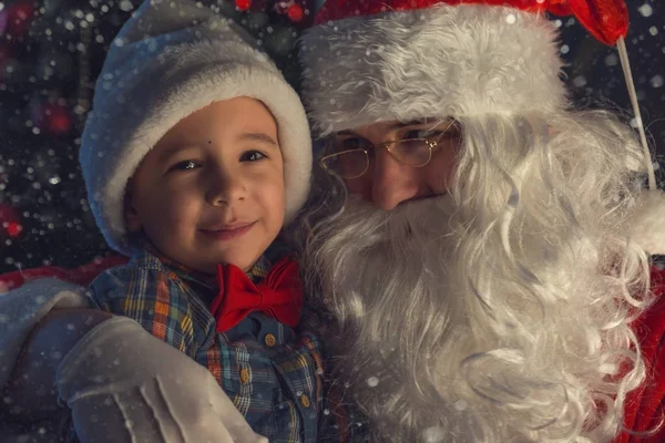 Retrato de un niño feliz con Papá Noel junto al árbol de Navidad — Foto de Stock