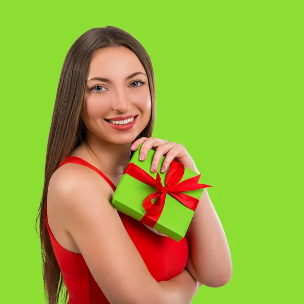 Retrato de una hermosa joven feliz con un regalo sobre un fondo verde —  Fotos de Stock