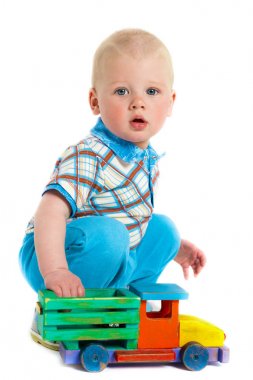 Beyaz zemin üzerinde bir oyuncak bir çocuk portresi. Ahşap bir araba ile küçük çocuk