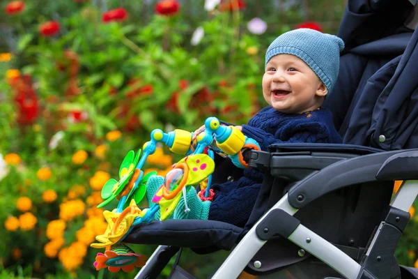 Portret van een gelukkig kind in een kinderwagen buitenshuis — Stockfoto