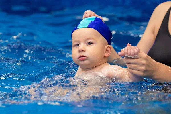 Spor aile. Bir çocuk havuzu olan bir kadın. Bebek yüzmeyi öğrenir