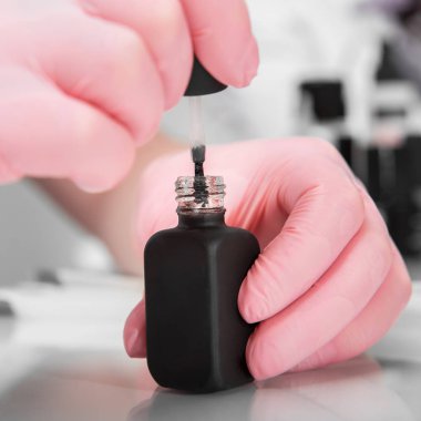 Tırnak cilası bir manikürcü elinde. Yakın çekim fotoğraf Güzellik Salonu