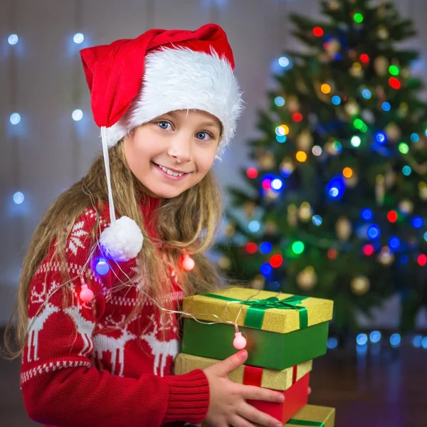 Retrato de un niño feliz con un regalo en el fondo de un árbol de Navidad —  Fotos de Stock