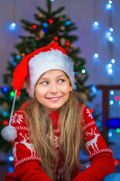 Retrato de uma criança feliz com um presente no fundo de uma árvore de Natal — Fotografia de Stock