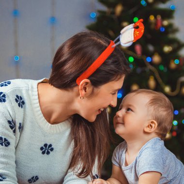 Mutlu bir çocuk ve bir Noel ağacı yakınındaki bir kadın portresi