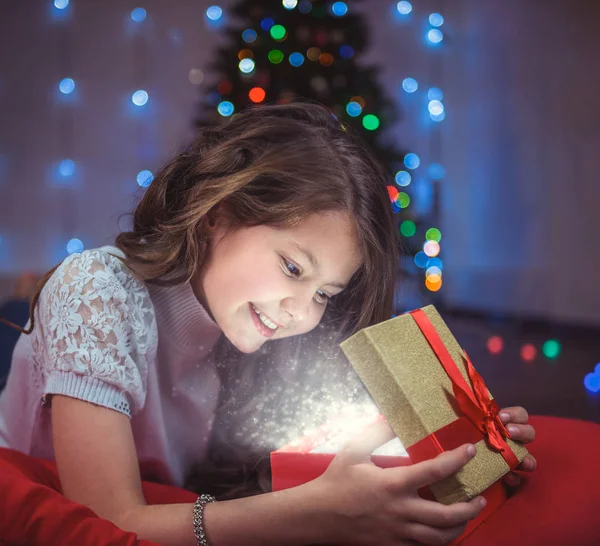 Retrato de un niño feliz con un regalo en el fondo de un árbol de Navidad —  Fotos de Stock