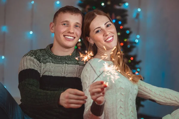 Potret Natal dari pasangan yang penuh kasih. Pria dan wanita di latar belakang pohon Natal — Stok Foto