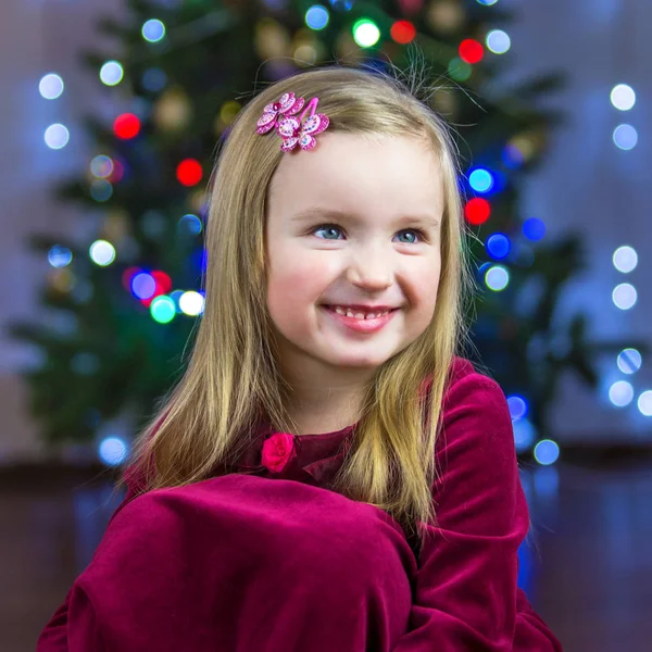 Retrato de uma criança feliz no fundo de uma árvore de Natal — Fotografia de Stock