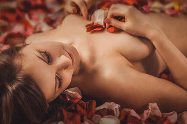 玫瑰花瓣上美丽的年轻裸体女人肖像 — 图库照片