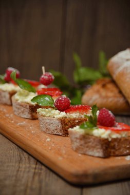 Meyve Ahududu ve ahşap bir bo üzerinde süzme peynir ile brusquest