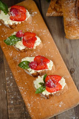 Meyve Ahududu ve ahşap bir bo üzerinde süzme peynir ile brusquest