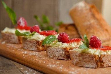 Meyve Ahududu ve ahşap bir bo üzerinde süzme peynir ile brusquest