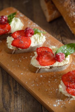 Meyve Ahududu ve ahşap bir bo üzerinde süzme peynir ile brusquest