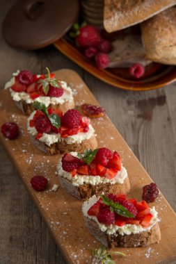 Meyve Ahududu ve ahşap bir bo üzerinde süzme peynir ile brusquest
