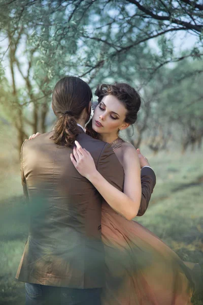 若い女性が男を抱いて花の咲くガーデン — ストック写真