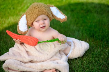 Bebek gibi bir bunny havuç oyuncak açık havada yeşil çimenlerin üzerinde ile şapkalı