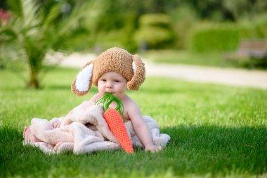 Bebek gibi bir bunny havuç oyuncak açık havada yeşil çimenlerin üzerinde ile şapkalı