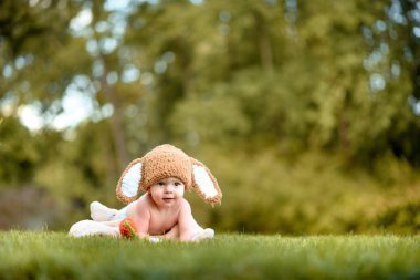 Bebek gibi bir bunny havuç oyuncak açık havada yeşil çimenlerin üzerinde ile şapkalı