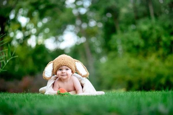 Bebek gibi bir bunny havuç oyuncak açık havada yeşil çimenlerin üzerinde ile şapkalı