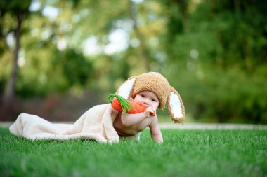 Bebek gibi bir bunny havuç oyuncak yeşil çimenlerin üzerinde ile şapkalı 