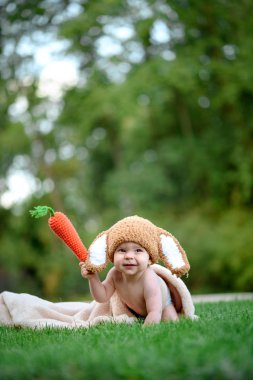 Bebek gibi bir bunny havuç oyuncak açık havada yeşil çimenlerin üzerinde ile şapkalı