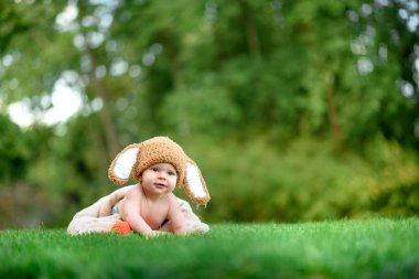 Bebek gibi bir bunny havuç oyuncak açık havada yeşil çimenlerin üzerinde ile şapkalı