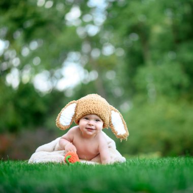 Bebek gibi bir bunny havuç oyuncak açık havada yeşil çimenlerin üzerinde ile şapkalı