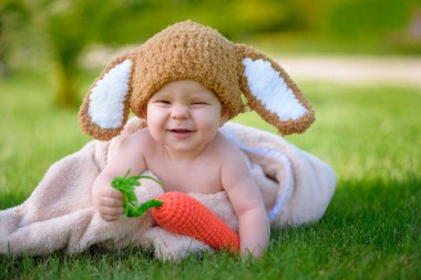 Bebek gibi bir bunny havuç oyuncak açık havada yeşil çimenlerin üzerinde ile şapkalı