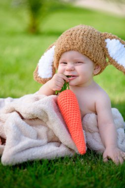 Bebek gibi bir bunny havuç oyuncak açık havada yeşil çimenlerin üzerinde ile şapkalı