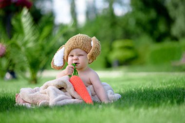 Bebek gibi bir bunny havuç oyuncak açık havada yeşil çimenlerin üzerinde ile şapkalı