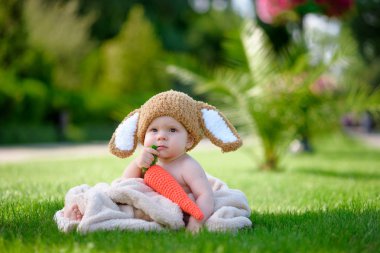 Bebek gibi bir bunny havuç oyuncak açık havada yeşil çimenlerin üzerinde ile şapkalı