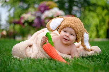 Bebek gibi bir bunny havuç oyuncak açık havada yeşil çimenlerin üzerinde ile şapkalı