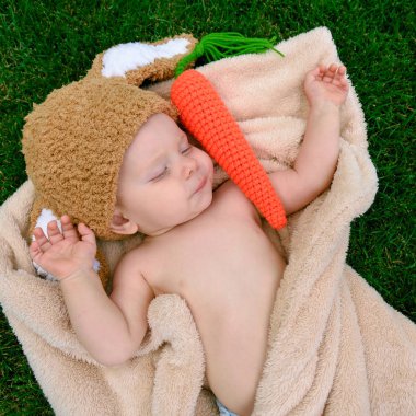 Bebek gibi bir bunny havuç oyuncak açık havada yeşil çimenlerin üzerinde ile şapkalı