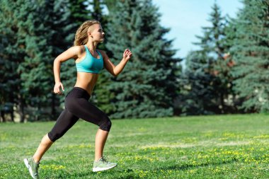 Şehir Parkı içinde çalışan genç mutlu kadın atlet. Sağlıklı fitness 